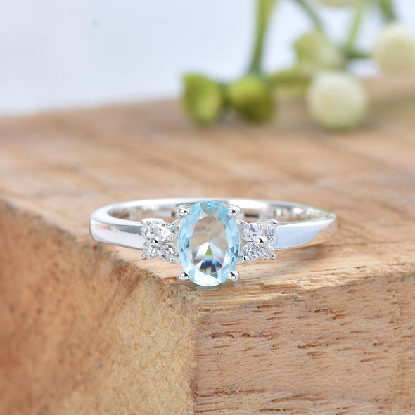7x5mm Oval Blue Topaz Ring with side Accents - 925 Sterling Silver